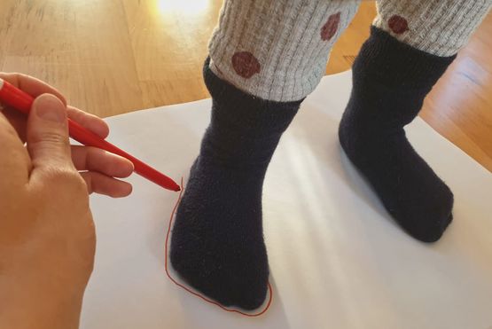Kinderfüße messen mit einer Schablone